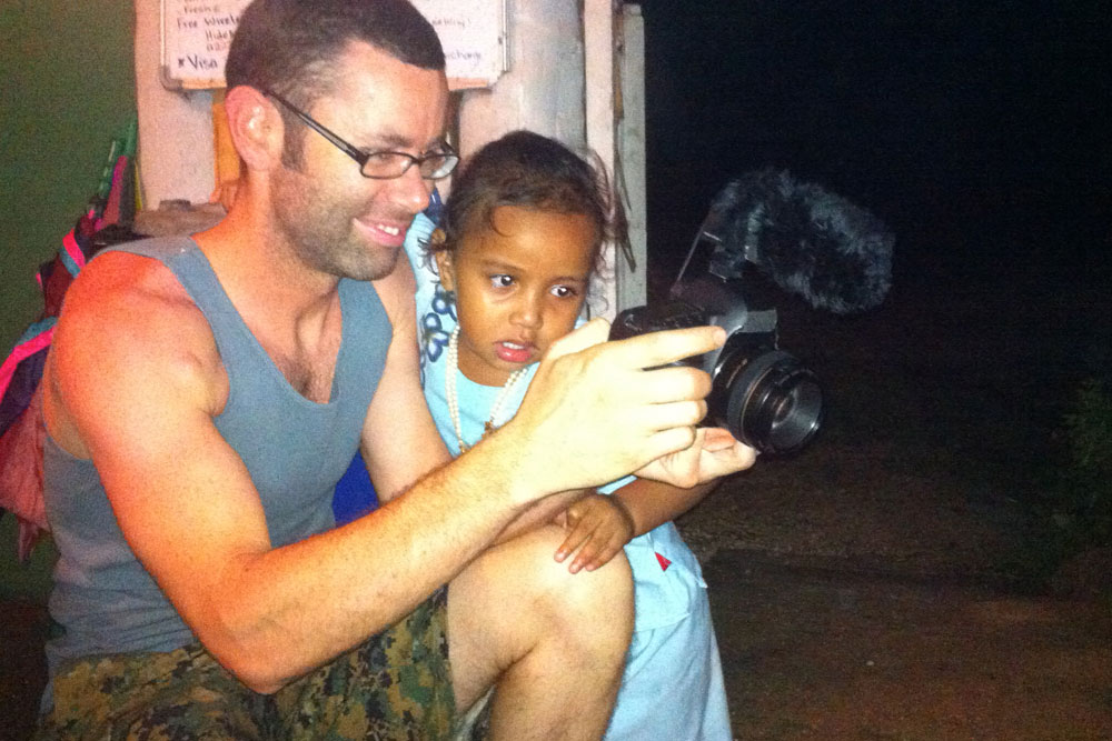 Derek shows Tufi a video.